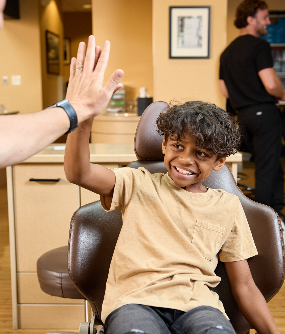 boy giving high five in dental chair