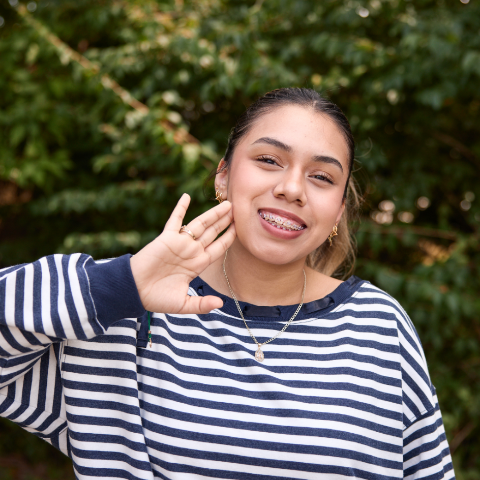 girl smiling with braces and hand to cheek