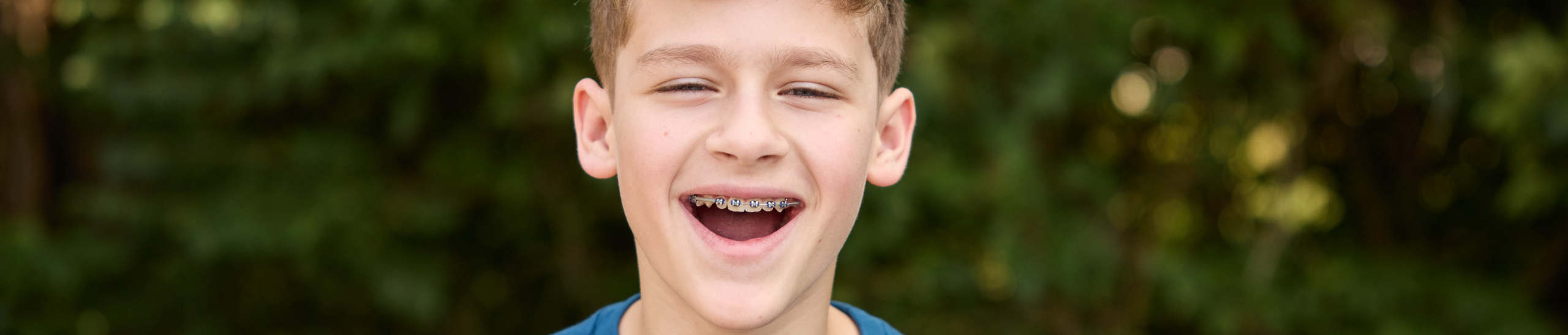 boy smiling big with braces