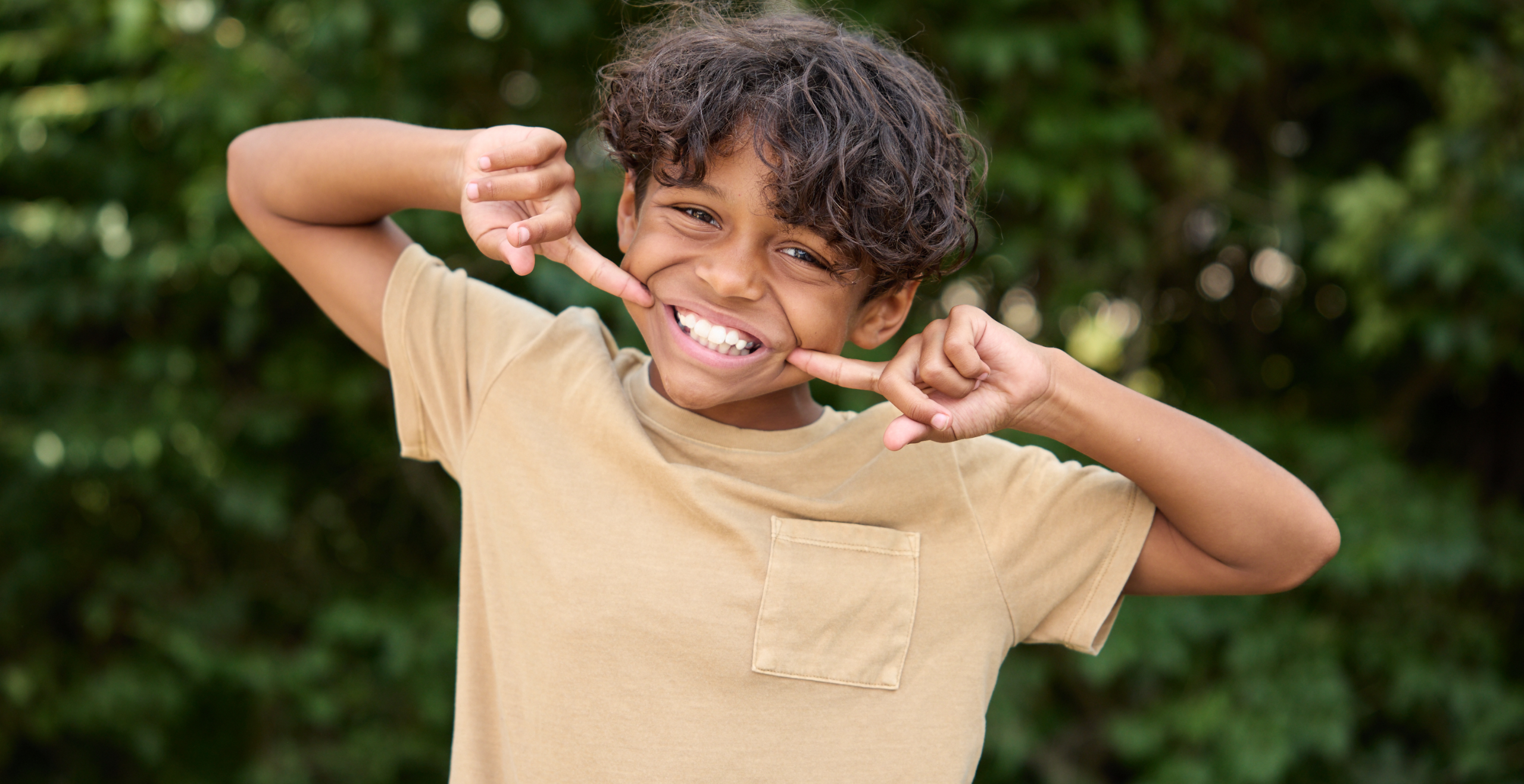 child smiling big and pointing at his mouth
