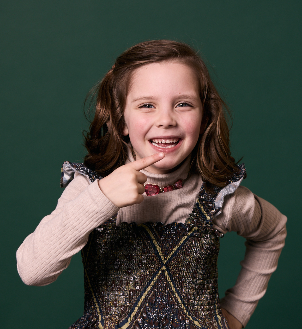 Little girl pointing to her mouth and smiling at Rochford Orthodontics.