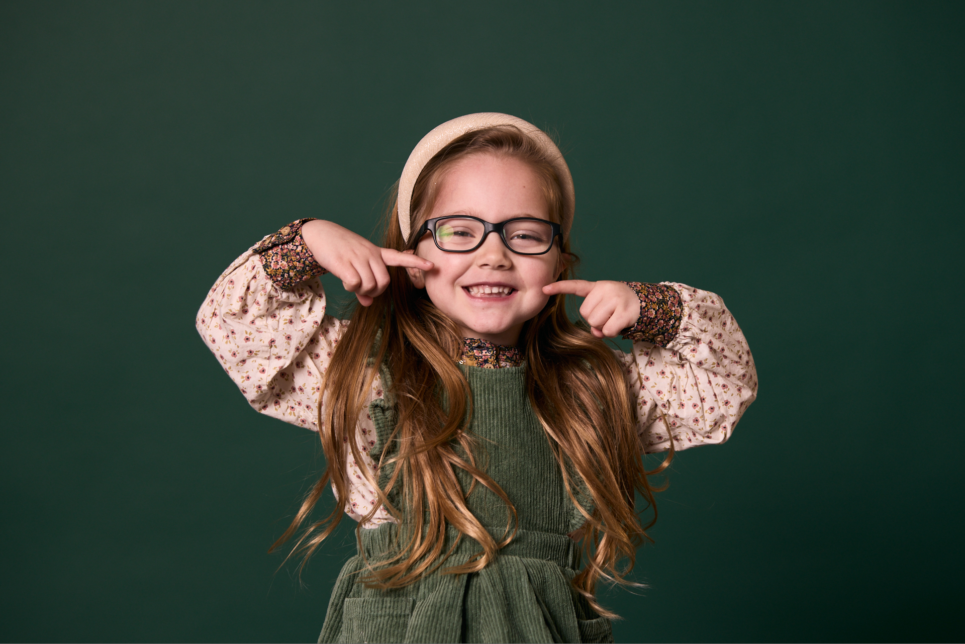 Little girl pointing to her mouth and smiling at Rochford Orthodontics.