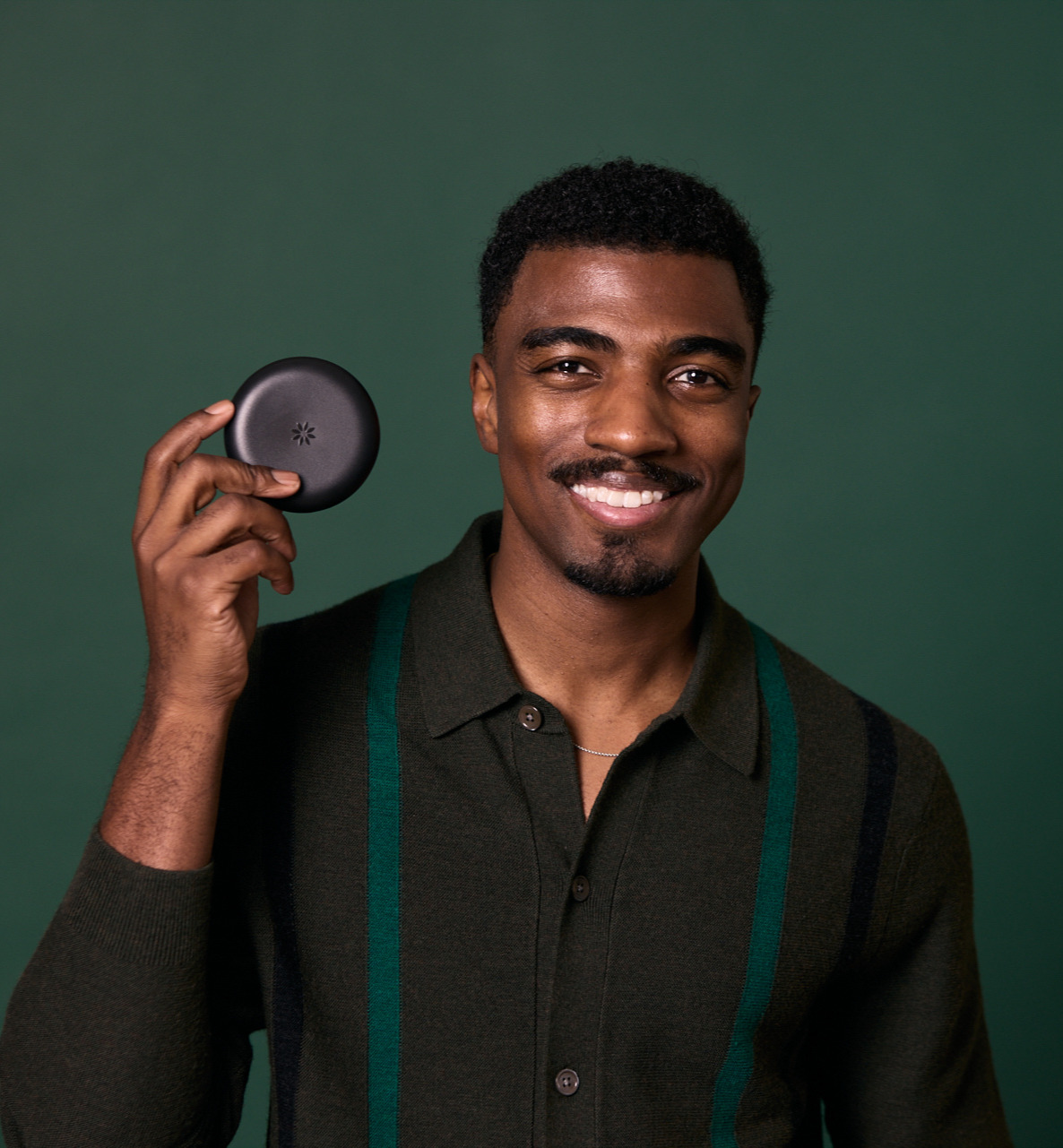 Man smiling holding Invisalign case at Rochford Orthodontics.